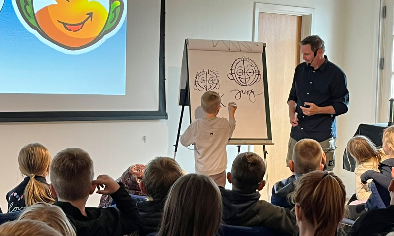 Jan Kjær tegner med en skoleelev